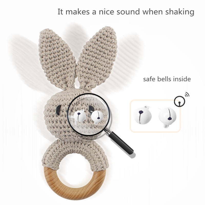 Baby holding a natural wooden teether toy