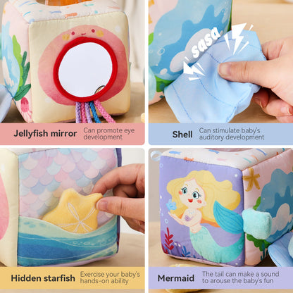 Baby pulling soft fabric tissues from sensory tissue box toy