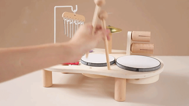 Toddler playing wooden musical instruments on Montessori music activity table